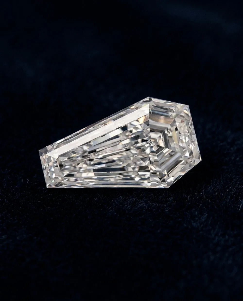 Elongated cushion-cut loose diamond on navy velvet