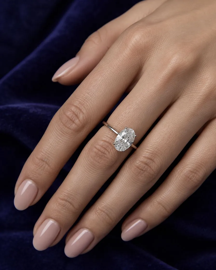 a 2 carat oval diamond solitaire on a hand, illustrative