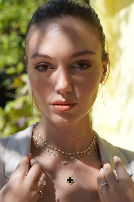 Model wearing a diamond necklace in soft sunlight