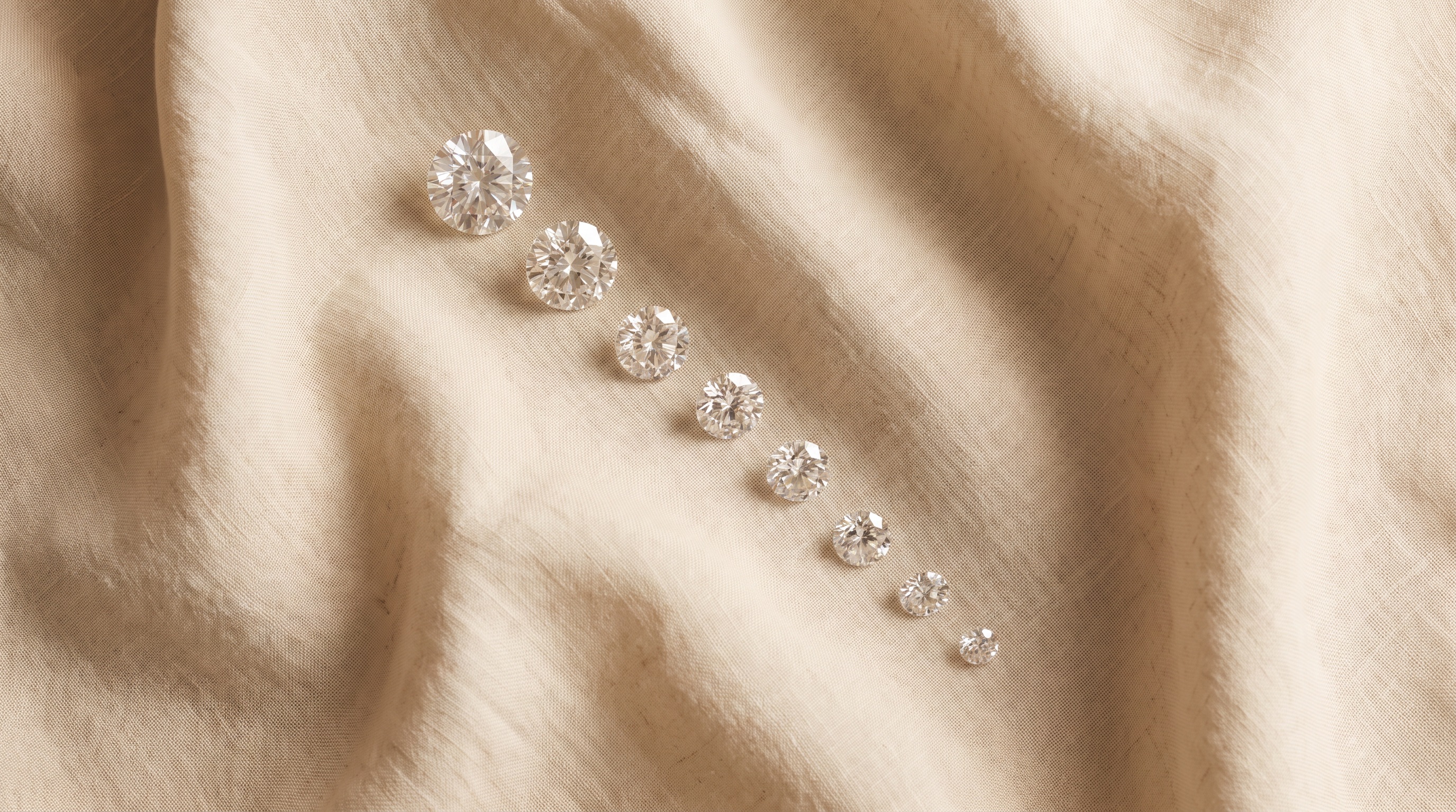 Three-stone engagement ring with emerald cut center flanked by matched shield cut diamonds, editorial jewelry photography