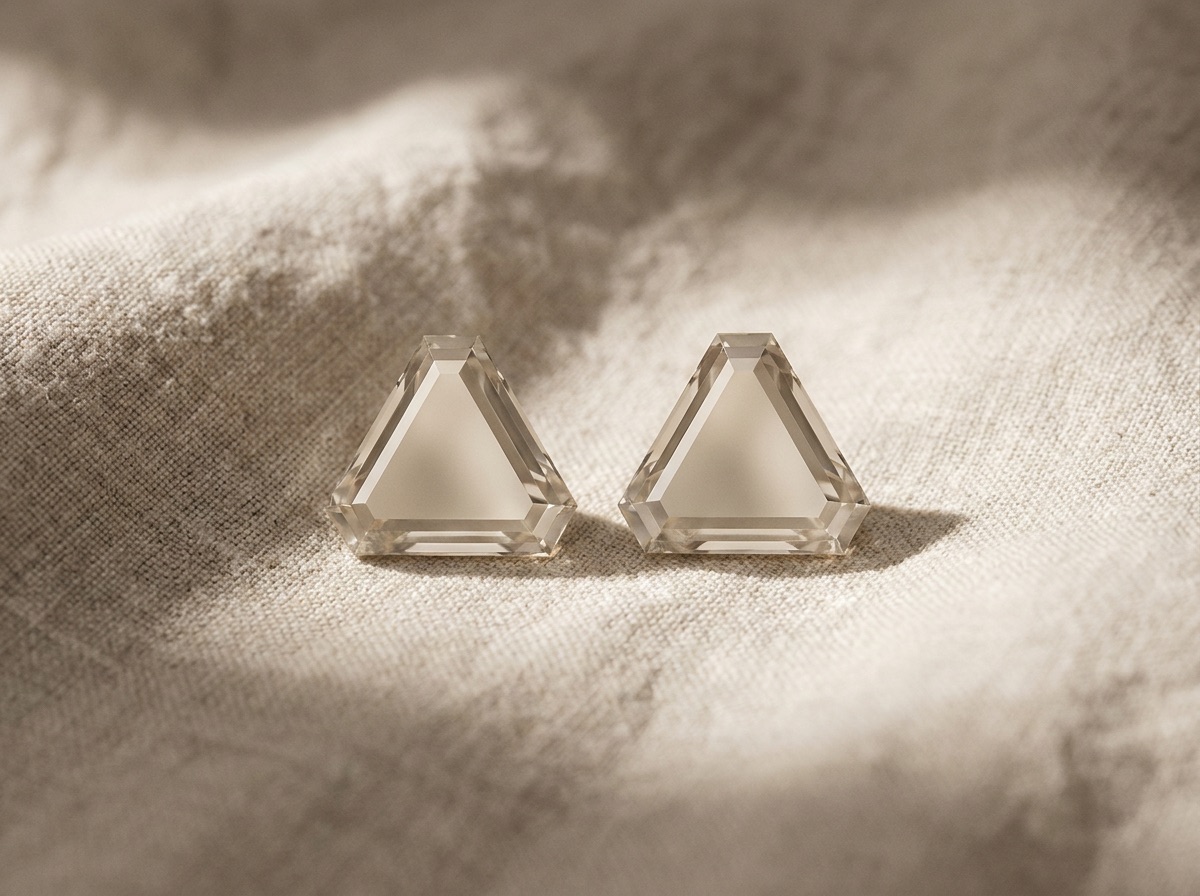 Macro close-up of a triangle cut diamond corner secured by a V-prong setting, cinematic dark background with single hard light